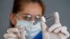 COVID-19 Coronavirus Vaccine. Doctor scientist with syringe analyzing virus Sars-CoV-2 in research for the vaccine.