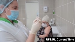 A nurse at Russia's Kemerovo Clinical Diagnostic Center prepares to vaccinate fellow nurse Olga Skripachenko  with the Sputnik-V vaccine on December 9, 2020.